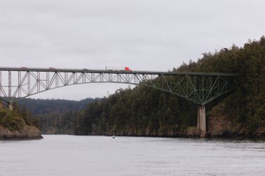 Bulutlu bir günde Aldatma Geçidi yakınındaki köprüden kamyon geçiyor