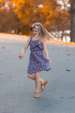 Genç bir gril sonbaharda sokaklarda dans ediyor.