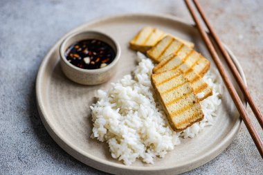 Pirinç, bbq dilimleri tofu peyniri ve soya sosu.