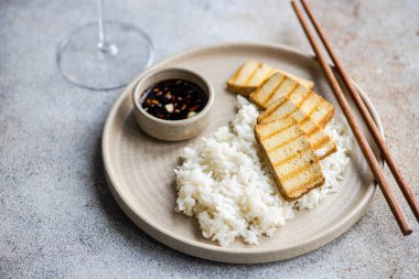 Pirinç, bbq dilimleri tofu peyniri ve soya sosu.