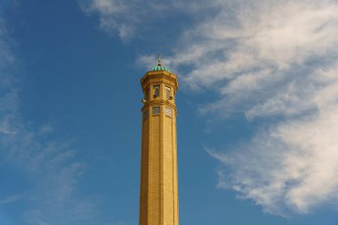 Tepesinde saat olan yüksek bir bina.