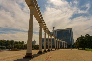 Arka planda bir bina olan uzun bir sıra sütun.