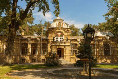 Önünde saat olan büyük kahverengi bir bina.