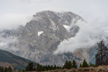 Engebeli dağ zirvesi sisli bulutlar tarafından kısmen gizleniyor