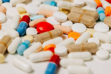 Beyaz arka planda birkaç renkli reçeteli ilaç var.