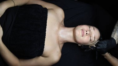 Müşteri kaplıcada yatarken yüz masajı yaptırıyor.