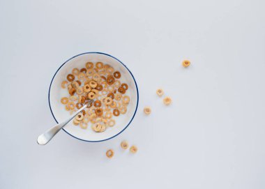 Bowl of cheerios breakfast cereal in milk on white background. clipart