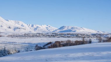 Karla kaplı kasaba dağlara kurulmuş. Kış mevsimlerini sergiliyorlar.