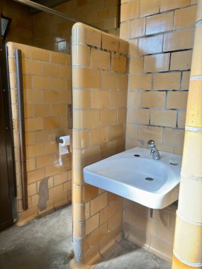 Lavabolu, tezgahlı, tuvalet kağıdıyla döşenmiş klasik umumi tuvalet.