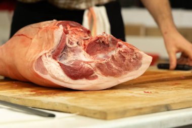 Close-up of a raw pork leg on a wooden table during butchering clipart