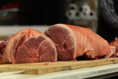 Close-up of fresh pork roasts on a wooden table during processing clipart