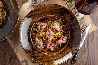 Sığır eti ve bir bardak şarapla sıcak salata.