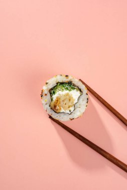 Renkli arka planda ton balığı ve çubuklarla yuvarlan