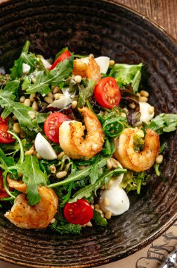 roka salatası, karides ve çam fıstığı.