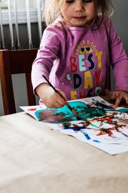 Küçük kız resmine odaklanmış.