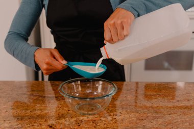 Kadın fırıncı, sos için krem ölçer.