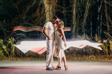 Couple sharing a romantic embrace with light trails glowing behind clipart