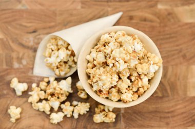 Kasede patlamış mısır ve koni, ahşap masada tepeden tırnağa görüş..