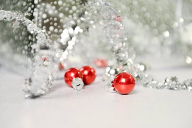 Close-up of red ornaments and silver tinsel with a festive, blu clipart