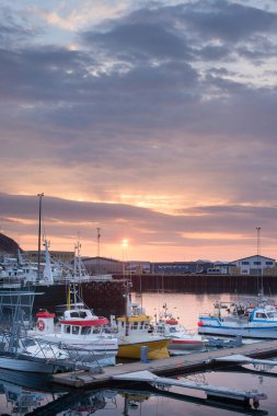 Limanda gün batımında tekneler ve yansımalarla