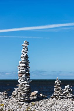 Deniz, kayalık plaj ve taş yığınları.