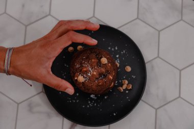 Hand grabbing peanut butter cookie off of plate clipart