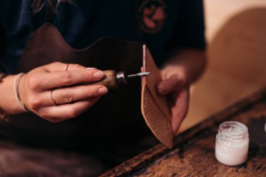 Leatherworker applying edge polish to a leather piece clipart