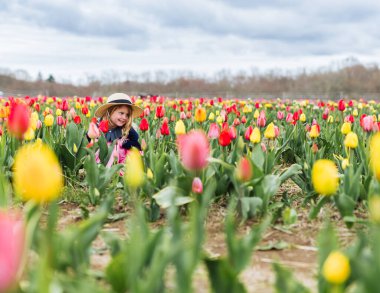 Lale tarlasında oynayan genç bir kız