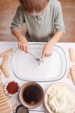 A child making homemade tiramisu clipart