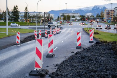 Üzerinde kırmızı beyaz çizgili işaretler olan bir yol.