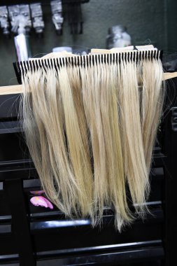 Sarışın uzantıları düzgün bir şekilde bir salonda askıya yerleştirilmiş..