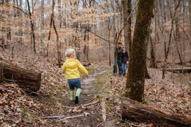Ormanda kış yürüyüşü yapan neşeli çocuklar.