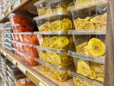 Muz cipsi ve kurutulmuş meyve dolu plastik kaplar.
