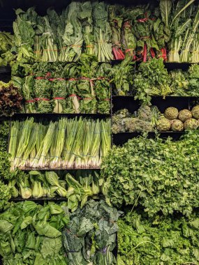 Fresh vegetable display featuring leafy greens, onions, and chard clipart