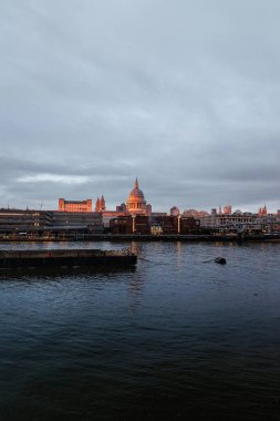 Güneşin batışı kasvetli bir günde Aziz Paul Katedrali 'nin kubbesini vurdu.