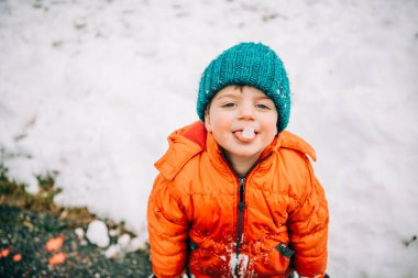 Smiling child holding ice on tongue clipart