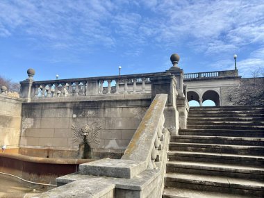Süslü balyaları olan taş merdiven ve canlı bir gökyüzünün altındaki çeşme.