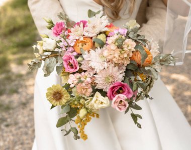 Turuncu ve pembe çiçekli bir çiçek buketi.