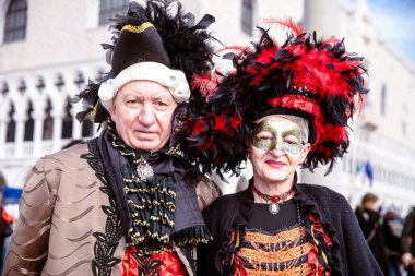 Venedik karnaval kostümlü, laboratuarlı yaşlı beyaz bir çift.