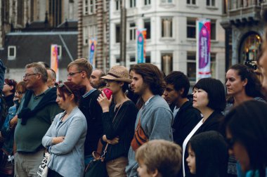 Sokaktaki insanlar Dam Meydanı, Amsterdam 'daki gösteriyi izliyor