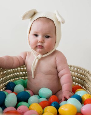 Pensive Easter Bunny Baby Sitting in Basket clipart