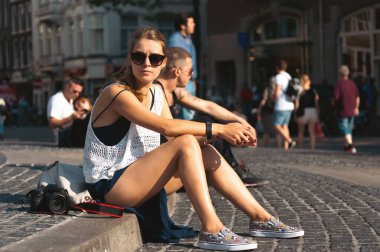 Amsterdam, Baraj Meydanı 'nda oturan genç kadın