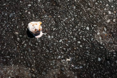 Yaz günü kaldırımda duran erimiş dondurma kepçesi.