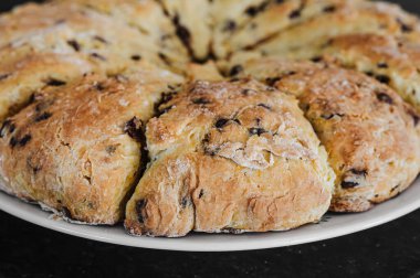 Siyah tezgahta portakal, çikolata parçalı çörekler.