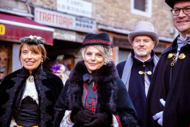 Bir grup yetişkin Kafkasyalı açık havada eski moda kıyafetler giyiyor.