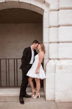 DIA, Detroit, MI 'de mermer kemerin altında nişanlı bir çift gülümsüyor..