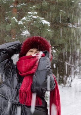 Kadın 50 yaşında, siyah ceketli ve kırmızı atkılı, S 'nin altında.