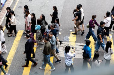 İnsanlar Hong Kong 'da sarı zebra geçidinden geçiyor.