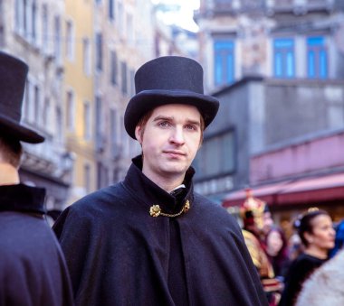 Tarihsel kostümlü, silindir şapkalı, beyaz bir erkek.