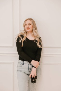 Kamerayı beyaz arka planda tutan kadın.